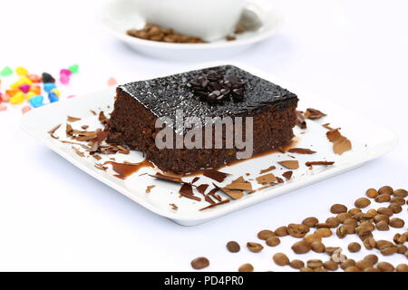 Square succosa spugna di cioccolato torta umida con la salsa in stampo e caffè Foto Stock