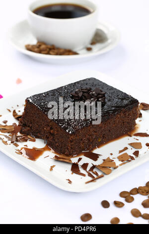 Square succosa spugna di cioccolato torta umida con la salsa in stampo e caffè Foto Stock