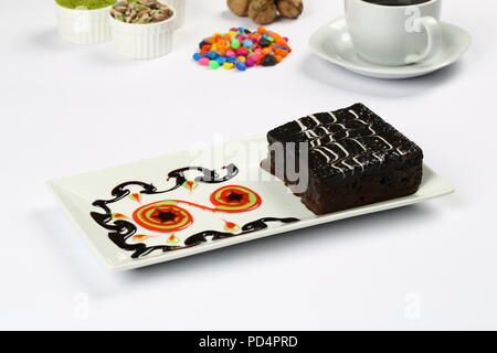 Square succosa spugna di cioccolato torta umida con la salsa in stampo e caffè Foto Stock