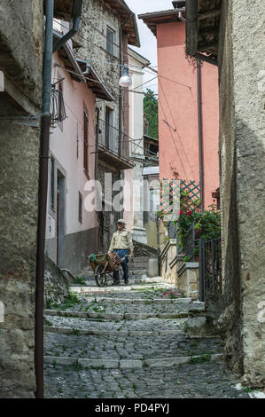 muratore con carriola in vicolo stretto. Regione Abruzzo, Italia, Europa Foto Stock