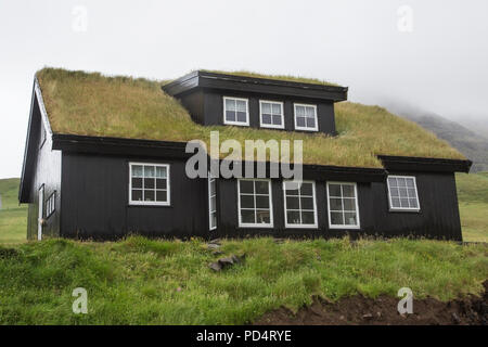 Edificio in Kollafjordur, isole Faerøer con tetto di tappeto erboso per isolamento Foto Stock