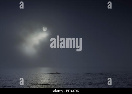 Nuvoloso notte di luna piena al mare Foto Stock