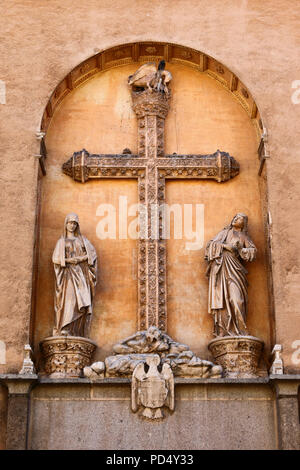 Croce e statue al di sopra di entrata di San Juan de los Reyes monastero, Toledo, Castilla la Mancha, in Spagna Foto Stock