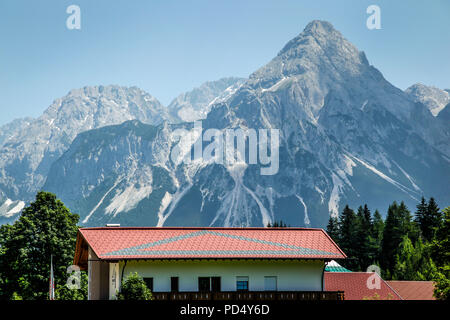 Vista dei monti Zugspitze nelle Alpi austriache in estate con villaggi vacanze e destinazioni turistiche Foto Stock