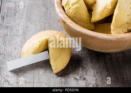Fortune Cookie nella ciotola di legno sul tavolo di legno Foto Stock