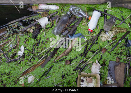 Bottiglie di plastica e altri pezzi di raccolti insieme galleggianti sulla parte superiore dell'acqua Foto Stock