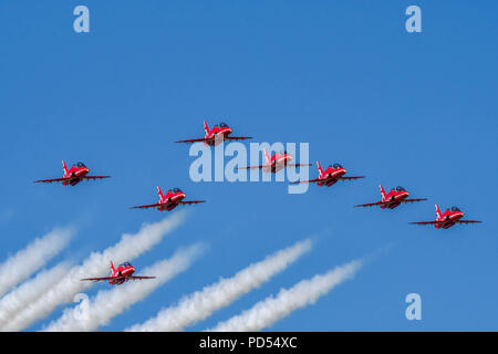 Otto aviogetti Hawk della Royal Air Force Aerobatic Team, le frecce rosse, volare in formazione su Cardiff Galles Aeroporto finale di fumo bianco Foto Stock
