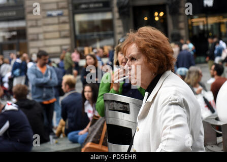 Donna di fumare sigarette in via della città di Vienna, Austria Foto Stock