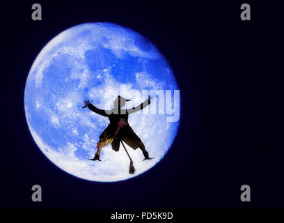 Una immagine composita per la festa di Halloween, costituito da un blu harvest moon con un inaspettato visitatore intonacate al suo volto. Questa strega era di fretta e ca Foto Stock