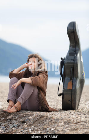 Giovane musicista sulla riva del mare, ritratto Foto Stock