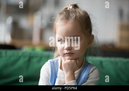 Grave pensieroso kid ragazza guarda lontano perso nel concetto di pensieri Foto Stock