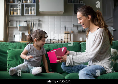 Mom sorridente dando eccitato kid confezione regalo con presente Foto Stock