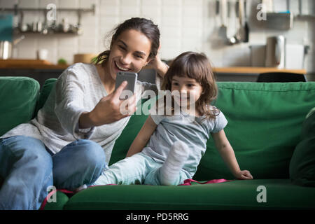 Felice madre ridere prendendo selfie con piccola figlia su smar Foto Stock