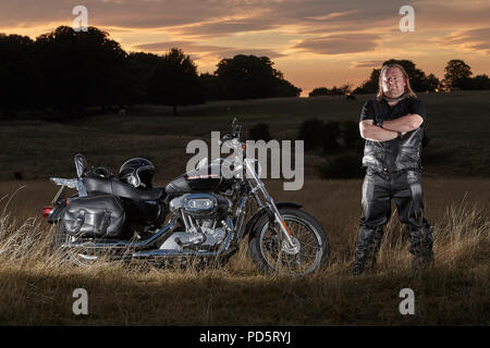 Rivestito in pelle biker in posa per un servizio fotografico sul suo custom Harley Davidson XL883 Sportster basso cruiser motociclo, sul Beverley westwood, East Riding Foto Stock