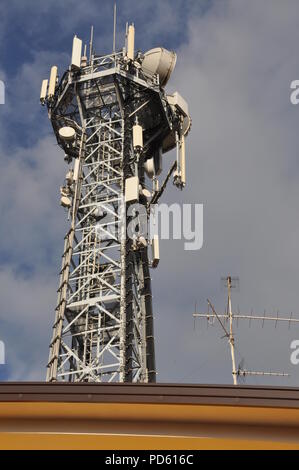 Torre di telecomunicazione con le antenne sopra la parte superiore di un edificio Foto Stock