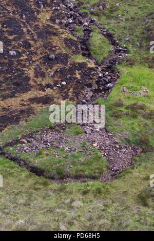 Masterizzazione di montagna che scorre verso il basso per Loch Diabaigas Airde attraverso arenaria Torridonian da wildfire bruciato Bracken. Torridon, Scotland, Regno Unito. Foto Stock