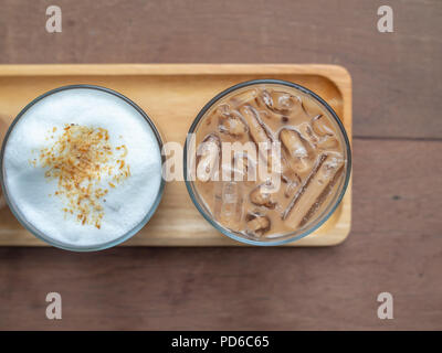 Piatto di laici due bicchieri di iced cappuccino il caffè sul tavolo in legno sfondo vista superiore. Foto Stock