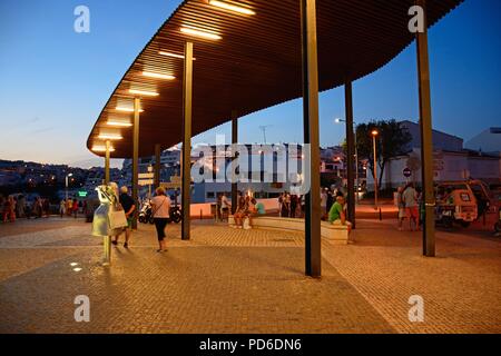 Statua di una donna prendendo una foto sul Miradouro do Pau da Bandeira mirador con turisti che si godono la fissazione al crepuscolo, Albufeira, Portogallo, Europa. Foto Stock