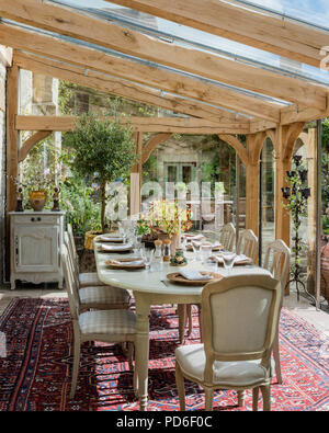 La sala da pranzo in vetro interno del conservatorio di antico casale in pietra del XIX secolo. Foto Stock