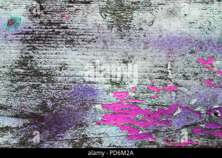 Texture in legno con colore verniciatura spellato. Sfald vernice. Legno sfondo grunge. Colorante incrinato sulla parete in legno. Viola e rosa irradiare colori su Foto Stock