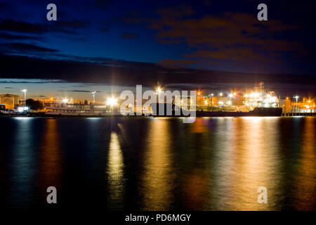 Auckland Harbour lights lunga esposizione foto della spiaggia con una grande nave di notte sotto il cielo blu Foto Stock