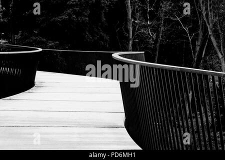 Bianco e nero passerella Ponte con ringhiera metallica e tavole di legno bw Foto Stock