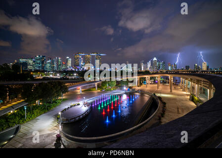Singapore punto di riferimento dello skyline della città presso il Marina Bay durante il tramonto tramonto con tuoni fulmini Foto Stock