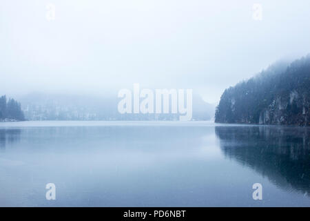 Lago di vuoto in inverno con calme e limpide acque e la nebbia all'orizzonte Foto Stock