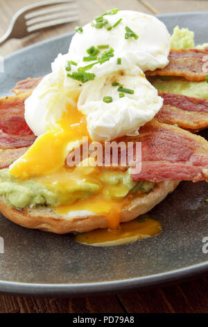 Uovo affogato e pancetta sul bagel prima colazione Foto Stock