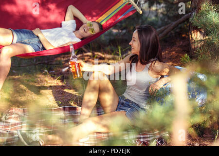 Partito, camping di uomini e donne gruppo alla foresta. Essi rilassarsi e mangiare barbecue contro erba verde. La vacanza estiva, avventura, lifestyle, concetto picnic Foto Stock