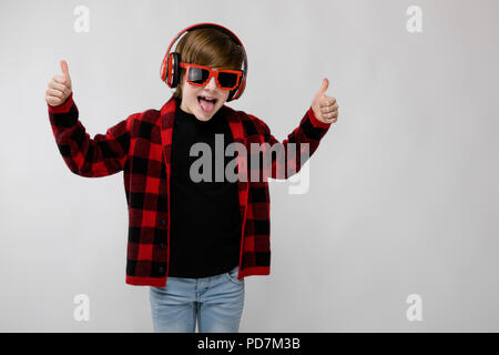 Ragazzo adolescente nel quartiere alla moda di clother e cuffie Foto Stock