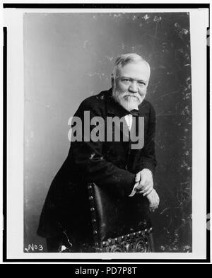 Andrew Carnegie, tre quarti di lunghezza verticale, poggiando su una sedia, rivolto verso la parte anteriore Foto Stock