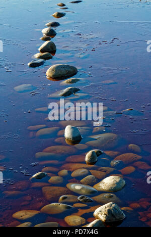 Pietre in acqua con pietre visibile sotto Foto Stock