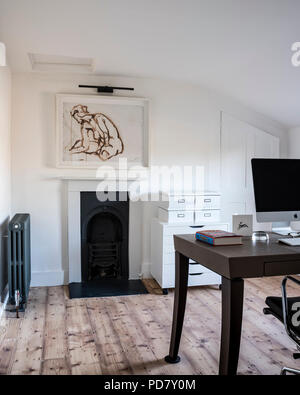 Chic home office con pavimento in legno e incorniciati acquerello da Ryan McElhinney, il piano di lavoro è Philippe Hurel e il deposito bokes da Ikea Foto Stock