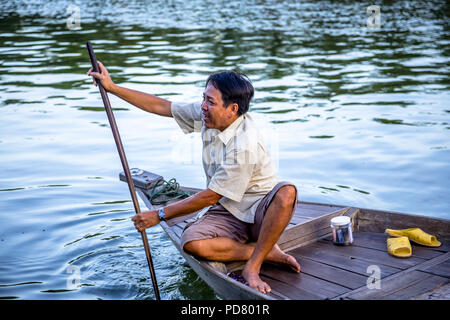 Editoriale: 14 agosto 2017, Hoi An, VN., antica cittadina fronte fiume barca con uomo di mezza età con pole cercando per i turisti per dare un giro. Foto Stock