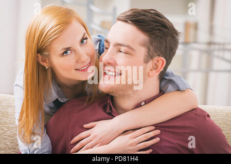 Sorridente giovane donna amare il suo udito uomo Foto Stock