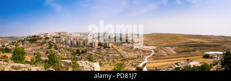 Vista panoramica dal campo di pastori, vicino a Betlemme, nella West Bank area palestinese con alloggiamento araba a metà del terreno, seguita dalla separazione Foto Stock