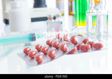 Pillole di placebo e di iniezione sul tavolo in labolatory Foto Stock