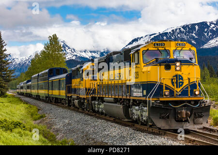 Montagne innevate sullo sfondo di Alaska Railroad costiera del treno classico da Anchorage a Seward Alaska Foto Stock