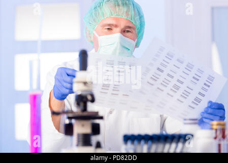 Scienziato analizing sequenza di DNA Foto Stock