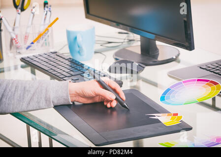Designer con tavoletta grafica in ufficio Foto Stock