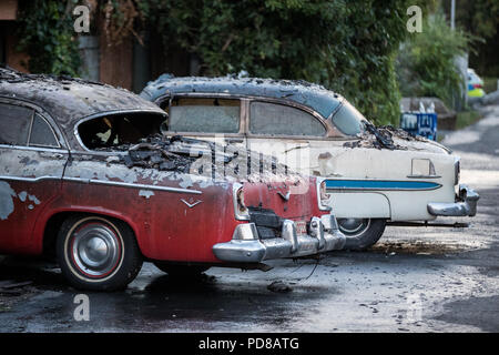 Siegburg Germania. 07 Ago, 2018. completamente bruciato auto d'epoca in piedi di fronte a un bruciato garage. Numerose case hanno preso fuoco a causa di un incendio direttamente sul Cologne-Frankfurt importante linea ferroviaria. Credito: Marcel Kusch/dpa/Alamy Live News Foto Stock