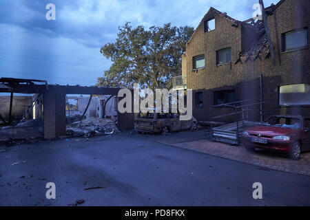 Siegburg Germania. 08 Ago, 2018. Un faretto illumina bruciate le case, garages e vetture dopo il fuoco su un terrapieno della linea di ghiaccio vicino a Siegburg. Numerose persone sono state ferite nel fuoco. Credito: Thomas Frey/dpa/Alamy Live News Foto Stock