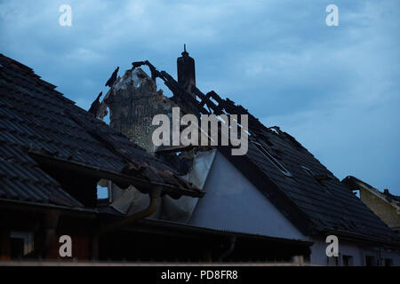 Siegburg Germania. 08 Ago, 2018. Un faretto illumina bruciate le case dopo un incendio su un terrapieno della linea di ghiaccio vicino a Siegburg. Numerose persone sono state ferite nel fuoco. Credito: Thomas Frey/dpa/Alamy Live News Foto Stock