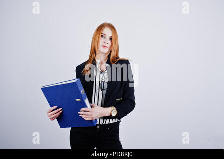 Ritratto di una imprenditrice redheaded indossando camicia a righe e una giacca con una cartella di blu. Foto Stock