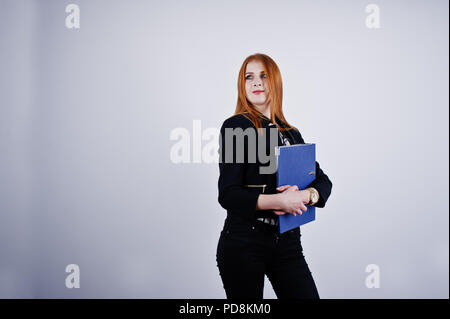Ritratto di una imprenditrice redheaded indossando camicia a righe e una giacca con una cartella di blu. Foto Stock