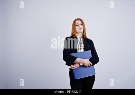 Ritratto di una imprenditrice redheaded indossando camicia a righe e una giacca con una cartella di blu. Foto Stock