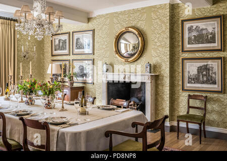 Cpnvex dorato specchio sopra il camino con in bianco e nero stampe incorniciate in sala da pranzo Foto Stock