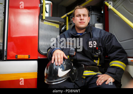 Foto del vigile del fuoco seduta in camion dei pompieri Foto Stock