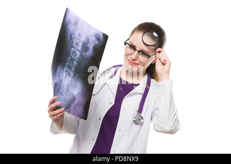 Attraente giovane donna medico guardando x-ray holding magnifier vicino la sua testa rendendo la diagnosi in divisa bianca su sfondo bianco Foto Stock